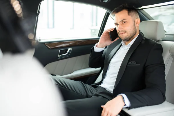 Eleganter Mann sitzt in luxuriösem Auto und telefoniert — Stockfoto