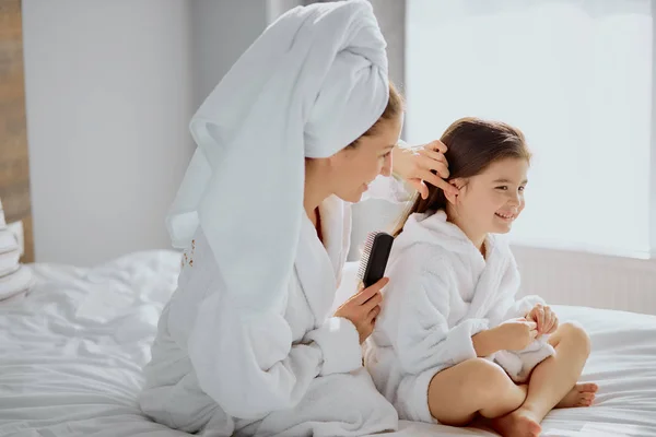 Feliz madre e hija ordenan después de la ducha, juntos en la cama — Foto de Stock