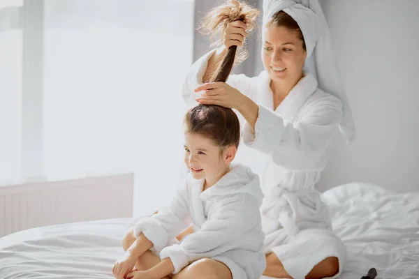 Caucásica madre atar la cola en hijas cabello —  Fotos de Stock