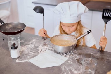 Küçük kız fırıncı fırın ve yemek ile ilgileniyor.