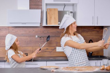 pozitif anne ve kız yemek pişirirken dans ediyorlar