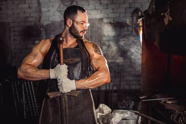 Atölyede el yapımı metal tutan adamın yan görüntüsü