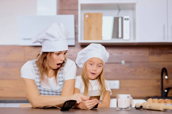 Madre e figlia sorpresa in cerca di ricetta — Foto Stock