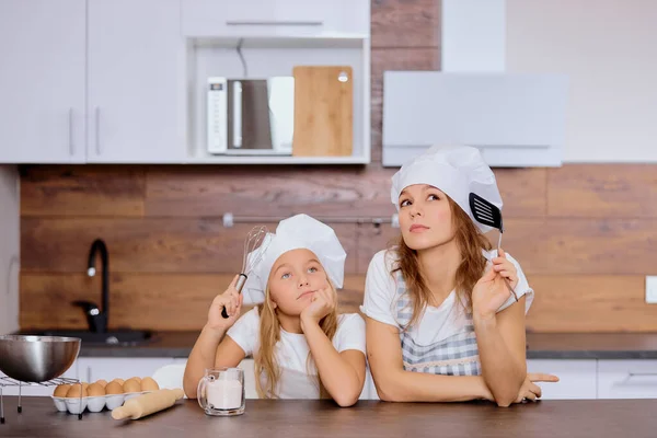 thoughtful woman and daughter dream about baking