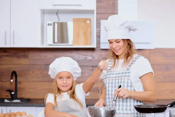 Positives Kind streut Mehl in Küche — Stockfoto