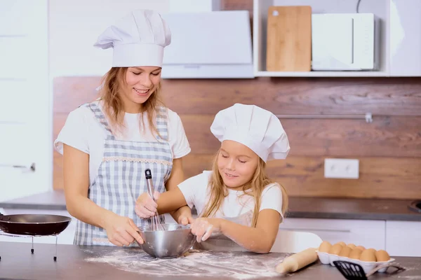 Щаслива біла мати і дочка випікають разом на кухні — стокове фото