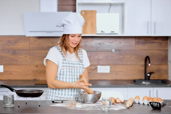 Красивая белая женщина делает тесто дома — стоковое фото