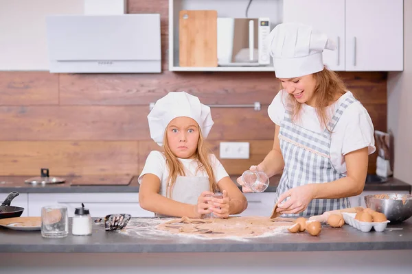 Little girl making dough with mother — Stock Photo, Image