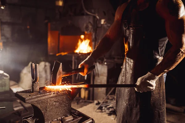 Herrero serio y seguro de sí mismo moldeando metal — Foto de Stock