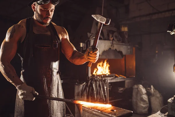 Hombre fuerte trabajando con martillo aislado en taller — Foto de Stock