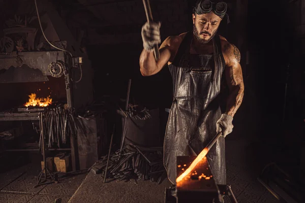 Starker Mann arbeitet mit Hammer isoliert in Werkstatt — Stockfoto