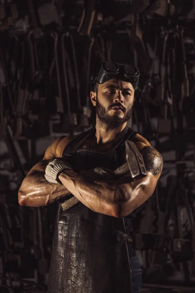 Retrato de un joven metalúrgico confiado y fuerte en delantal negro — Foto de Stock