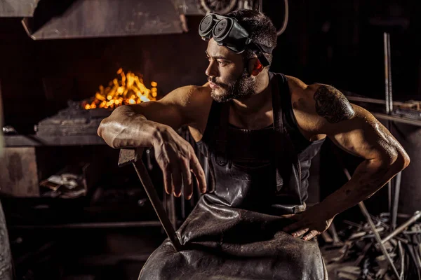 Portrét chladného kováře sedícího a odpočívajícího po práci — Stock fotografie