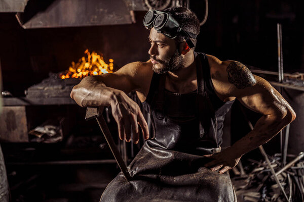 portrait of cool blacksmith sit having rest after work