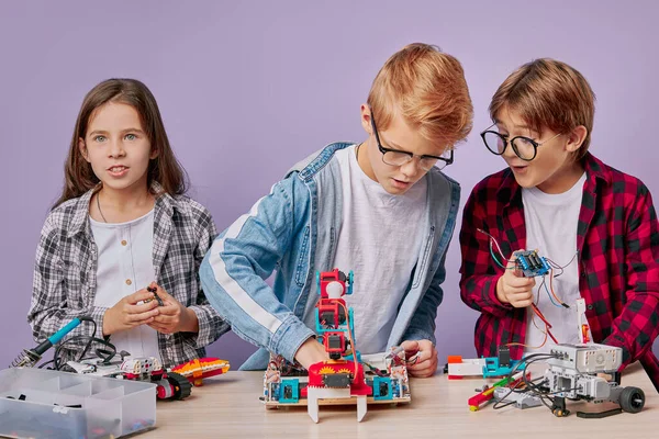 Praca zespołowa dzieci montaż roboty izolowane — Zdjęcie stockowe