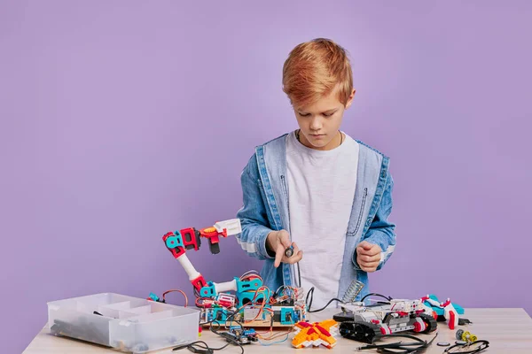 聪明聪明的男孩穿休闲装组装机器人 — 图库照片