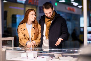 Genç, beyaz, evli bir çift kadın için mücevher seçmekten zevk alıyor.