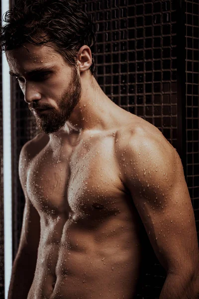 muscular bearded man in shower