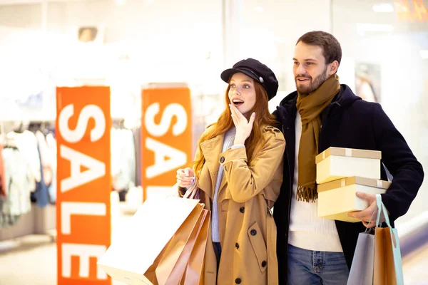 Sorprendido pareja caucásica de compras en el centro comercial — Foto de Stock