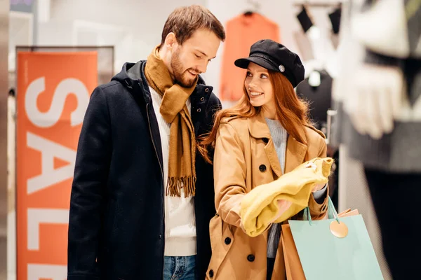 Mujer pelirroja joven que busca una blusa en la tienda junto con su marido — Foto de Stock