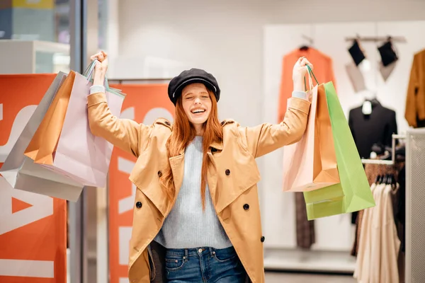 Felice giovane donna con le borse della spesa in negozio — Foto Stock
