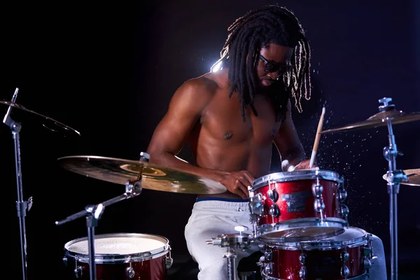 Giovane nero maschio colpire, eseguire musica rock utilizzando drum set — Foto Stock