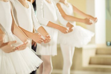 Kırpılmış küçük kızlar sıra sıra bale yapıyorlar.