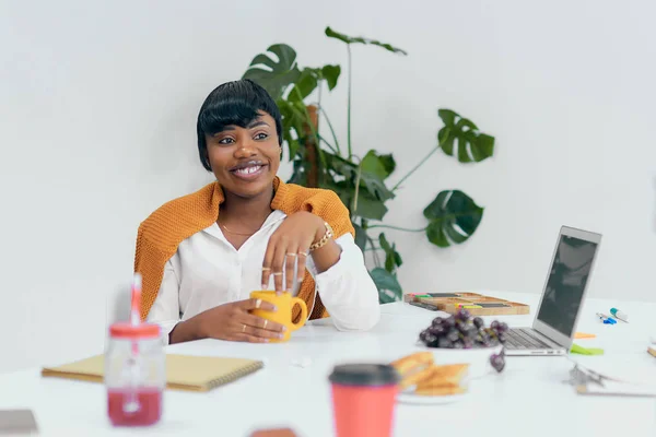 Lächelnde Afrikanerin am Arbeitsplatz im weißen Büro — Stockfoto