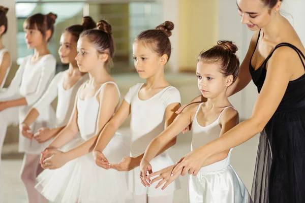 Jovem bailarina profissional praticando e ensinando crianças — Fotografia de Stock
