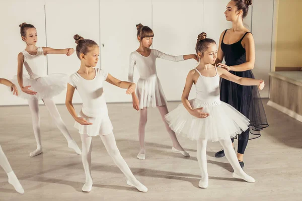 Jovem bailarina profissional praticando e ensinando crianças — Fotografia de Stock