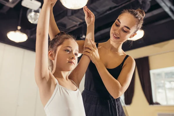 Молодой тренер балетной школы помогает молодым балеринам — стоковое фото