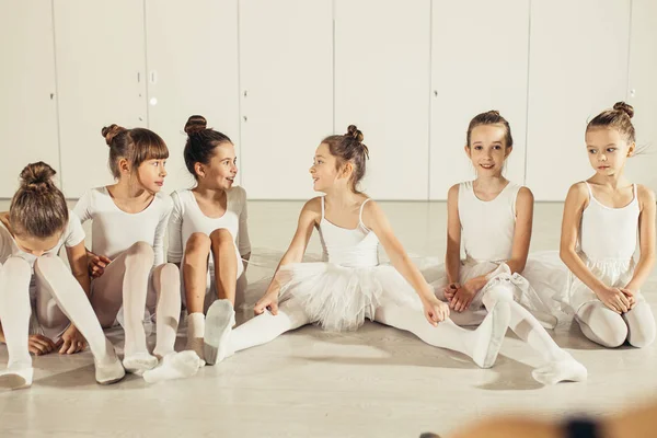 Grupo de bailarinas crianças engraçadas e felizes sentadas no chão — Fotografia de Stock