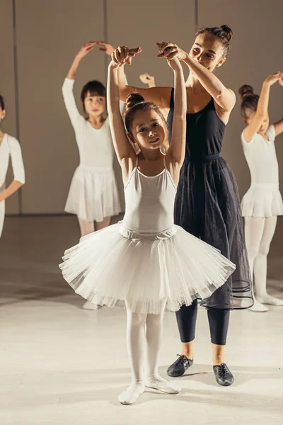 Joven bailarina profesional enseñando a las niñas a bailar —  Fotos de Stock