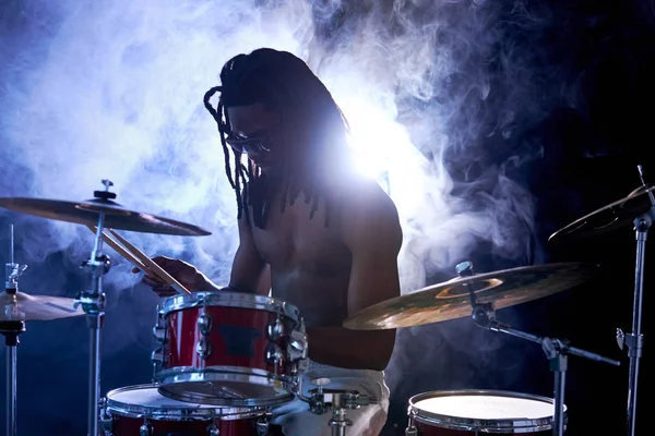 Силует барабанщика сидить на барабанах ізольовано над димом — стокове фото