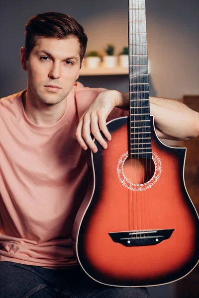 Retrato de jovem caucasiano agradável posando com guitarra isolada — Fotografia de Stock
