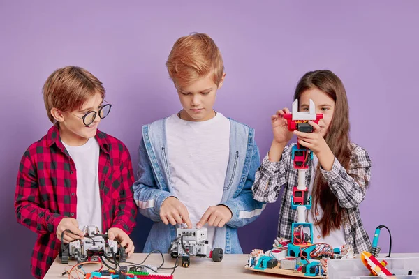 Education, science, technology concept. caucasian children with electric toys and building robots — Stock Photo, Image