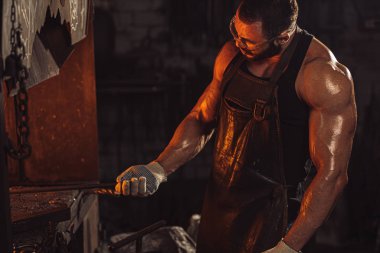 Kafkasyalı bir demirci bir atölyede çalışıyor.