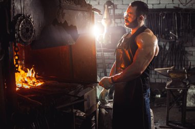 Kafkasyalı demirci şömine ve soba üretimi için demir ürünleri yapıyor.