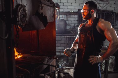 Kafkasyalı bir demirci bir atölyede çalışıyor.