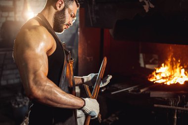Kafkasyalı demirci şömine ve soba üretimi için demir ürünleri yapıyor.