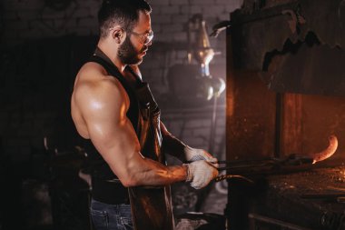 Kafkasyalı demirci şömine ve soba üretimi için demir ürünleri yapıyor.