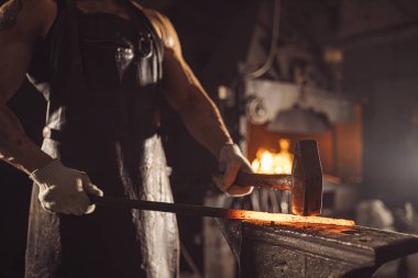 Genç kalpazan sıcak metal tutuyor.