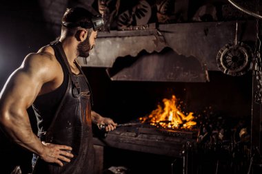 Kafkasya 'nın genç siyahı, fırında çelik parçalarını ısıtırken sıcak sıcaklıkta.