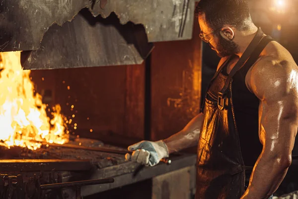 Giovane fabbro caucasico, operaio del ferro, artigiano, maestro artigiano in officina — Foto Stock