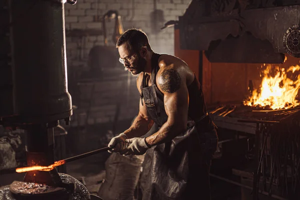 鍛冶工房での鋼製武器製造に油圧プレスを使用した鍛冶屋 — ストック写真