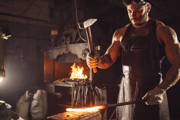 Hübscher Mann arbeitet in Werkstatt mit Hammer — Stockfoto