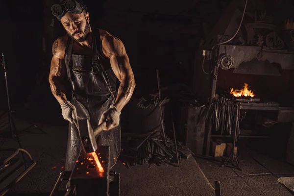 Giovane uomo caucasico battendo metallo caldo — Foto Stock