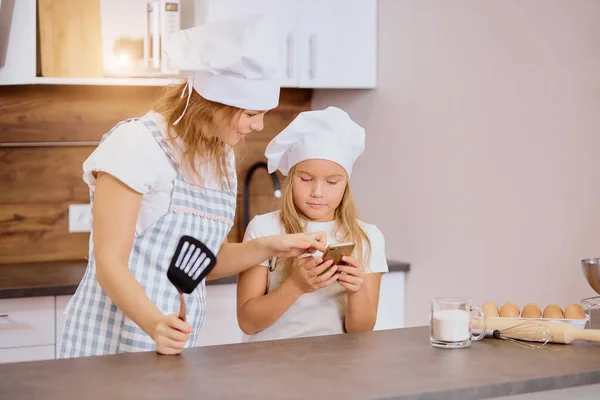 woman and kid girl prepare baking in kitchen