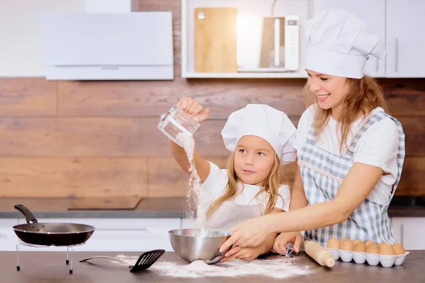 Gelukkig Kaukasische moeder en dochter bakken samen in de keuken — Stockfoto