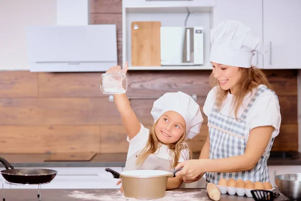 Schöne Kind Mädchen Streuen von Mehl in der Küche — Stockfoto